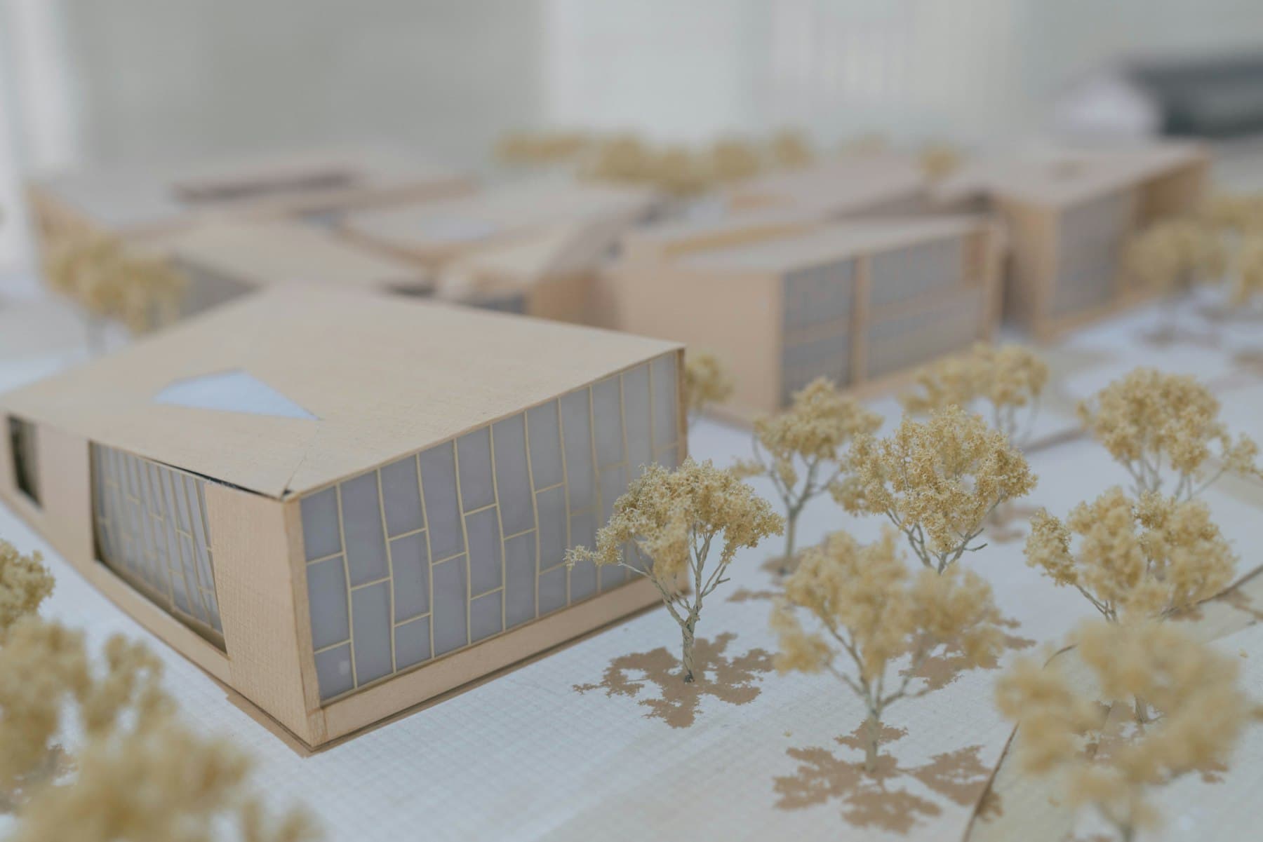 An architectural model of a low-rise development set among model trees.